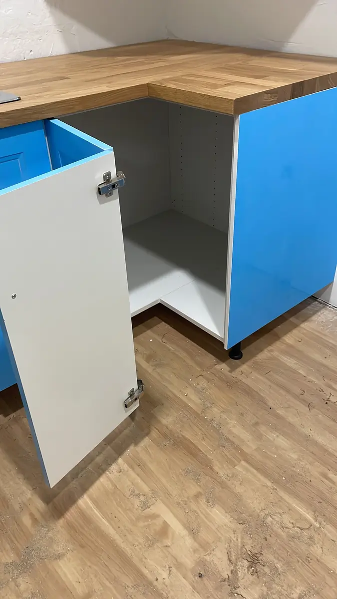Open corner cabinet showing fitted interior and concealed hinges